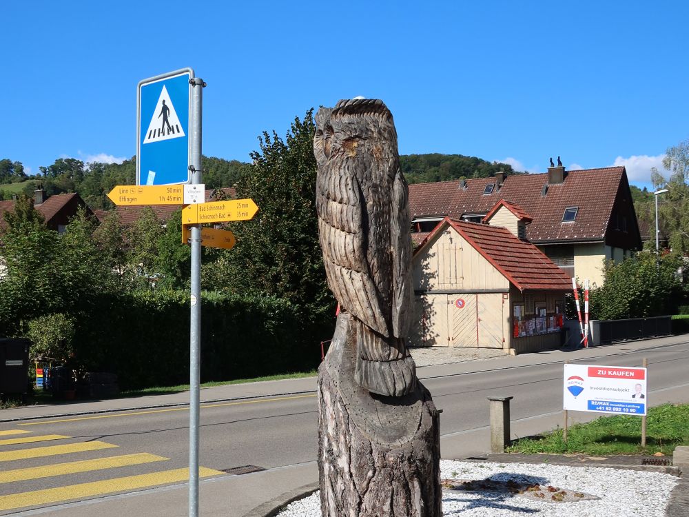 Holzfigur und Wanderwegweiser