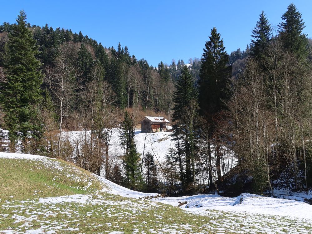 Hütte zwischen Schneeresten