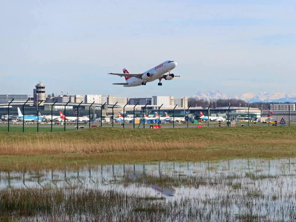 Flughafengebäude und startendes Flugzeug