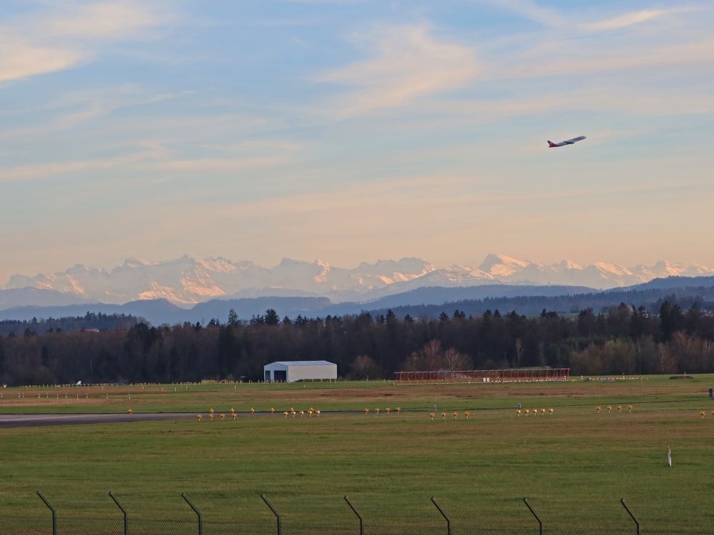 startendes Flugzeug über den Alpen