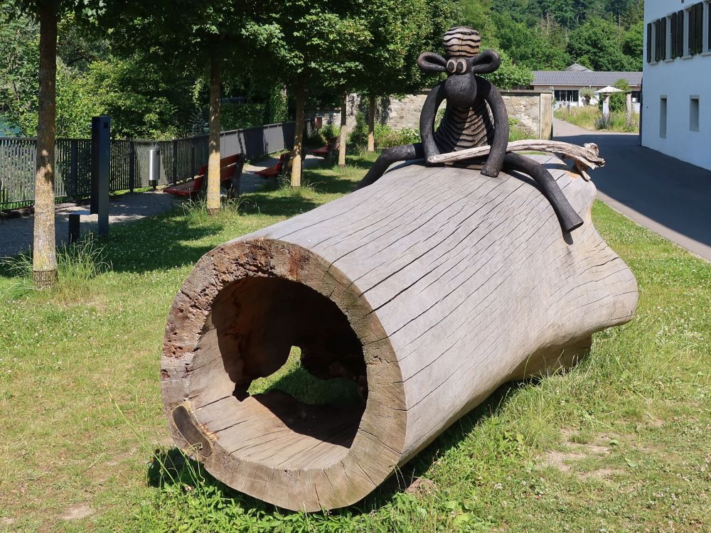 Affe auf hohlem Baumstamm
