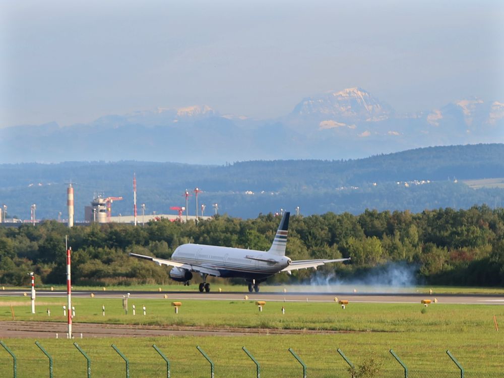 Flugzeug mit Bremswolke und Tödi im Dunst