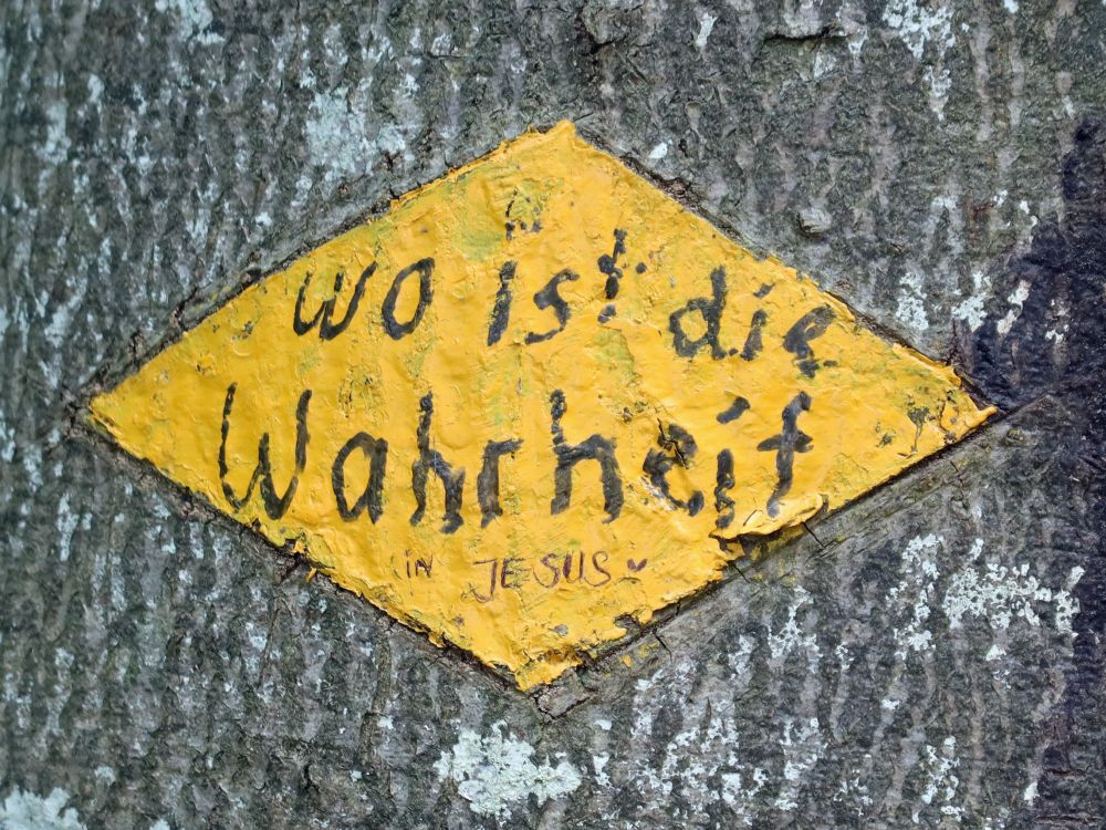 Botschaft auf Wanderwegmarkierung