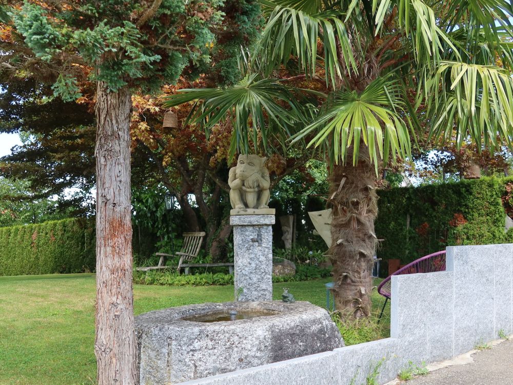 Brunnen mit Skulptur und Palmen